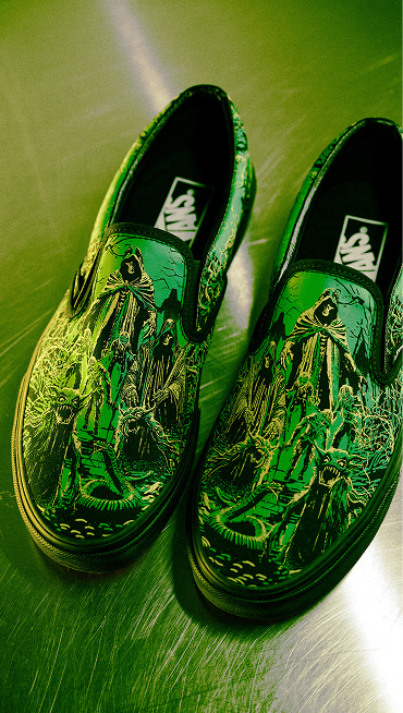 An overhead shot of the spooky green and yellow Halloween graphic on the Classic Slip-On as part of the Vans Halloween collection.