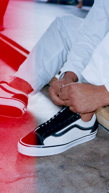 A person tying the OTW by Vans X Shoyoroll shoe wearing light colored jeans. 
