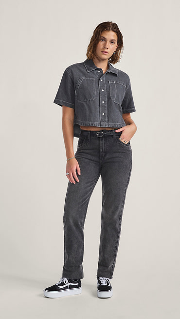 A young woman poses in a photography studio wearing black Annabelle pants.
