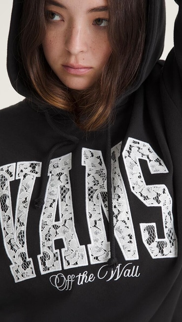 A close-up of a young woman wearing a black Laced Up Retro Hoodie.