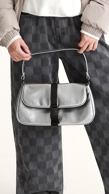 A woman holding the Shop Hooked On Bag in a photography studio.