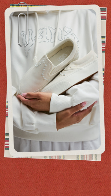 Close-up of someone in a white hoodie holding pearlized Classic Slip-On.