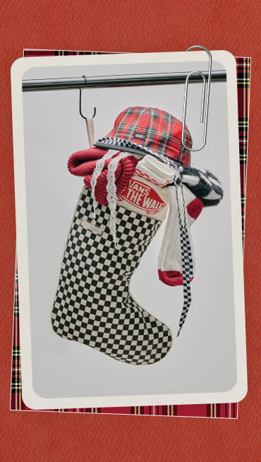 A photograph surrounded by a red holiday border of Vans accessories including hats, socks, and beanies crammed into a Checkerboard stocking.