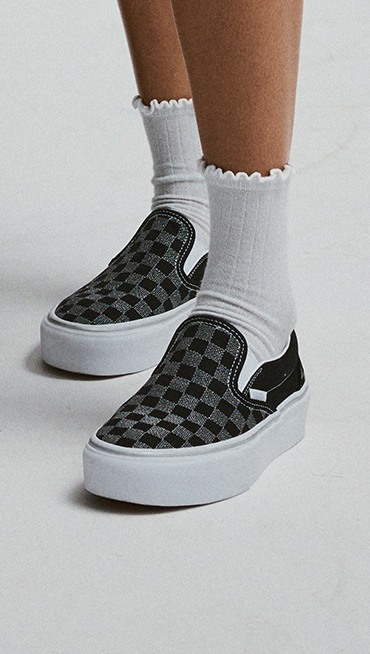 Close-up on the silver glitter checkerboard pattern on the black and silver Classic Slip-On Platform Checkerboard.