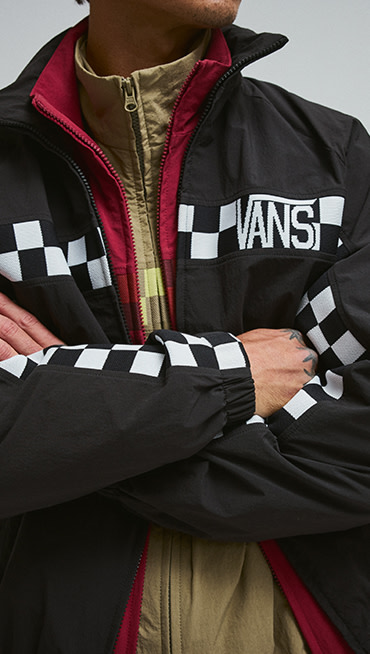 Close-up on a young man wearing all three colors of the Ronnie Track Jacket layered over each other.