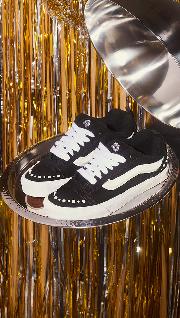 A pair of black Knu Skool Pearlized being served on a silver platter with gold New Years decorations in the background.