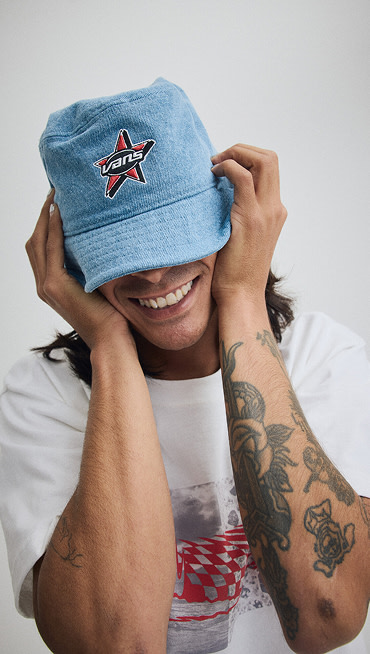 Close up of someone pulling down their Denim Vans Bucket Hat over their eyes.