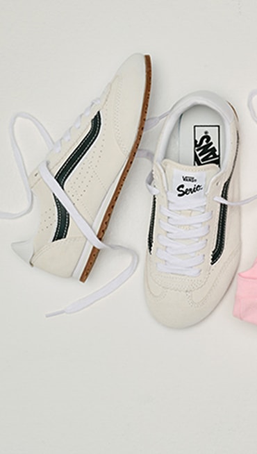 Close up of the Big Kids Super Lowpro Shoe in Marshmallow White laying on the floor of a grey photography studio.