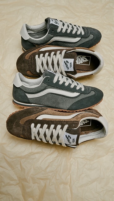 Alternating pairs Super Lowpro shoes in Demitasse Brown and Pewter Grey on the ground with a crumple paper background.