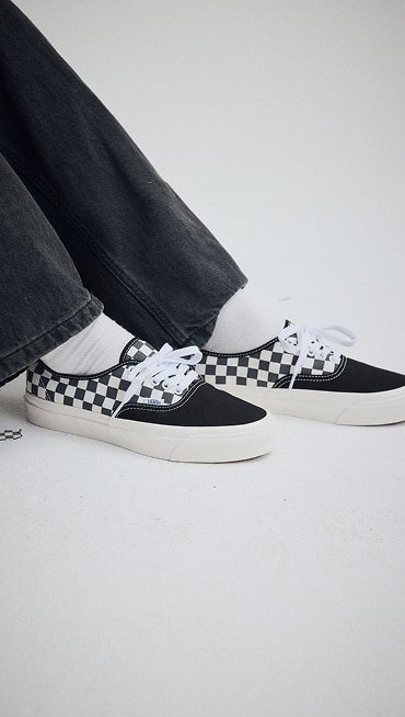 Close up of a man wearing Premium Authentic Checkerboard Shoe in Checkerboard Asphalt Grey / White.