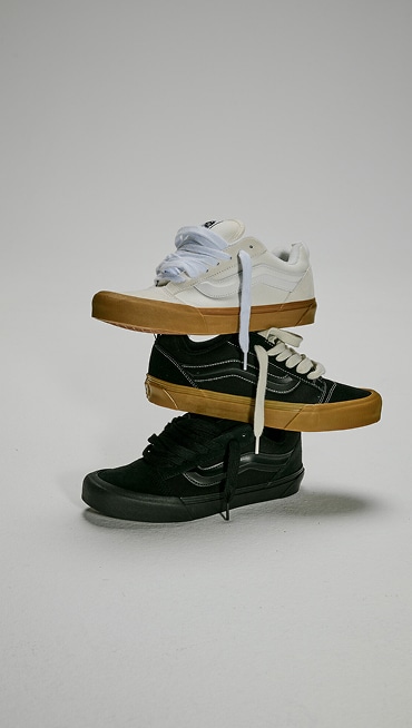 Three Knu Skool Shoes stacked on top of one another. Top is the Blanc De Blanc White, middle is the Gum Black, bottom is the Black.