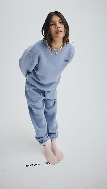 Wide shot of a woman wearing New Salton Crew Neck Fleece in Glacial Slate Blue with Salton Fleece Jogger Pants in the same color.