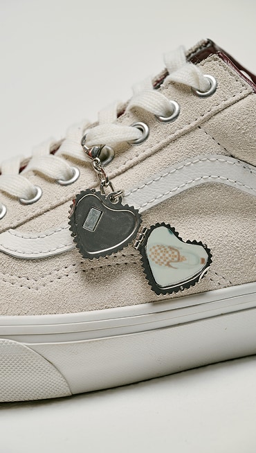 Extreme close-up of the Old Skool Shoe in the Valentine's Day themed Blanc De Blanc White colorway with an open heart shaped locket on the side.