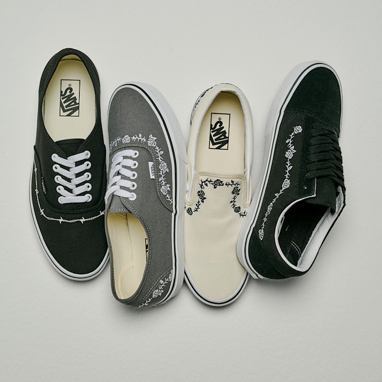 Top down view of different embroidered shoes with roses, thorns, and barbed wire including one Old Skool, Two Authentic Shoe, and one Classic Slip-On.