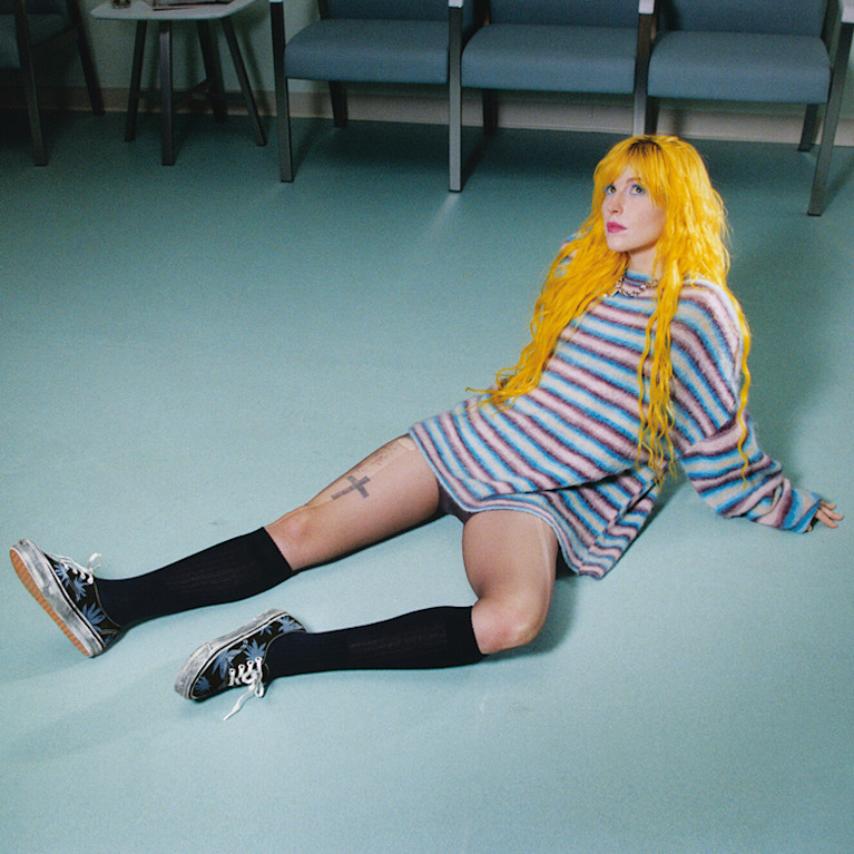 Paramore singer Hayley Williams lying on the floor of a waiting room wearing floral black and blue Authentic from the Worn Loud Authentic Legacy drop.