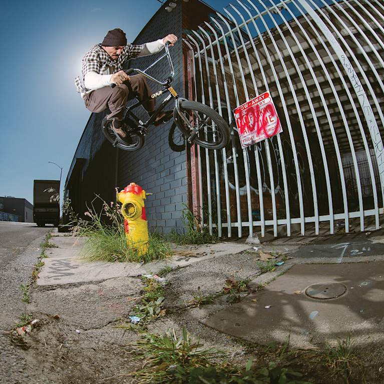 Vans Skate Team Rider Dakota Roche jumps over a fire hydrant in an industrial area wearing the Skate Era WaffleCup.