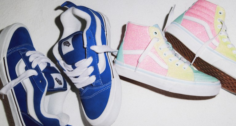A pair of Kids' Knu Skool shoes and Sk8-Hi shoes lay on the floor together.