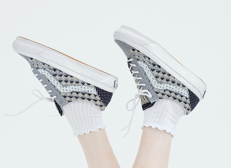 A person throws their Premium Old Skool shoes in the air while on their back in a photography studio.