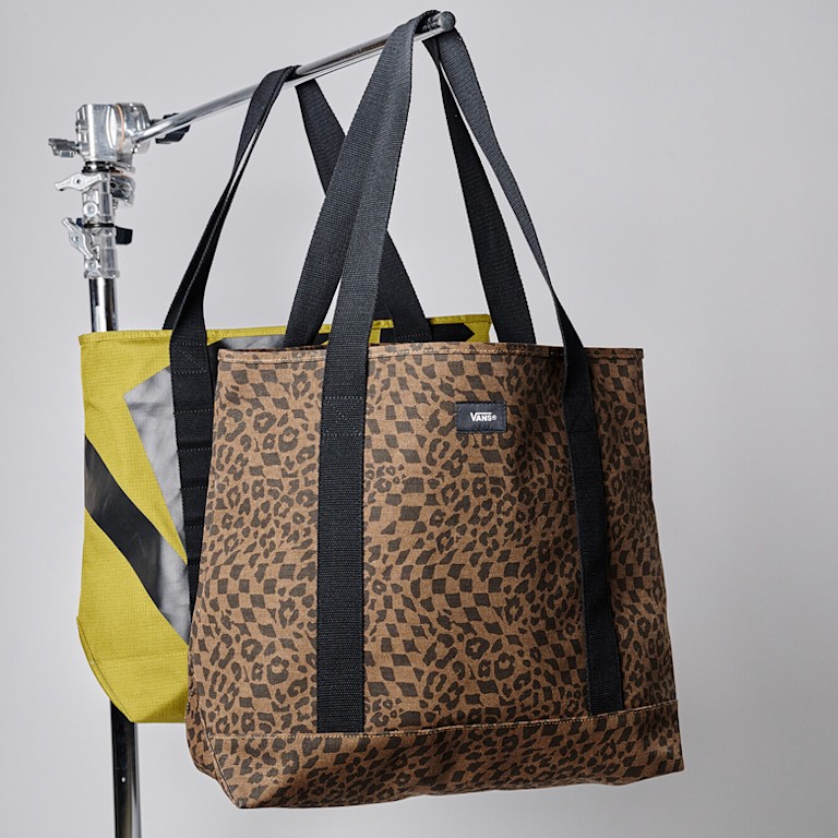 A Dachshund Brown handbag hanging on a rack in a photography studio.