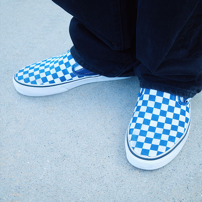 A close-up of stylist Landon wearing blue Checkerboard Classic Slip-On on the set of Open Set Los Angeles.