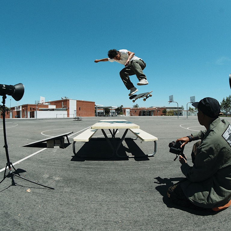 Vans Skate Team Rider Nick Michel jumping off a playground table wearing white Skate Half Cab from the United Through Skateboarding collection.