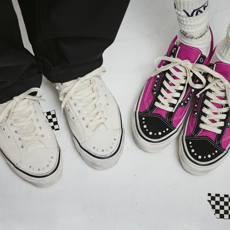 Two people standing in a photography studio wearing the white colorway and the magenta and black colorway of the Premium Old Skool 36 Pearlized.