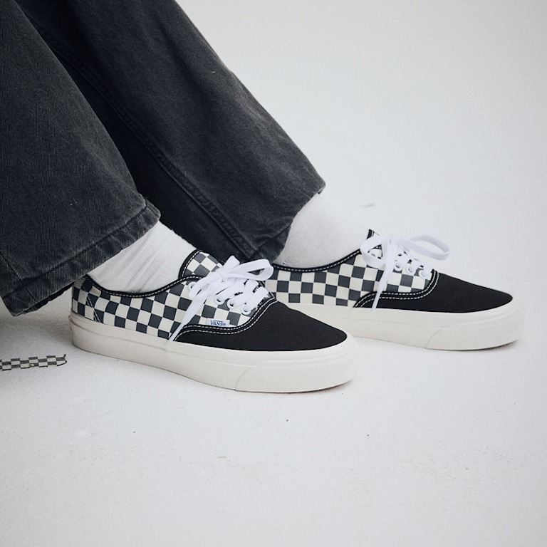 Wide shot of someone wearing a pair of the Premium Authentic Checkerboard Shoe in Checkerboard Asphalt Grey / White.