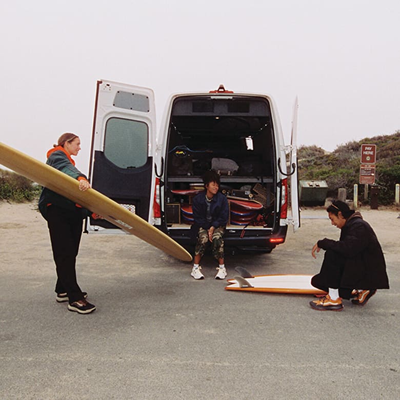 Surfers sitting in their van wearing vans apparel and shoes