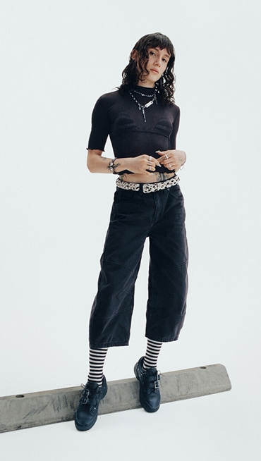 Vans Skater Efron Danzig poses on a curb in a photography studio wearing her Premium Old Skool from the New Future collection.