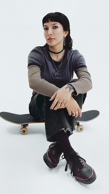 Vans Skater Tania Cruz sits and poses on a skateboard in a photography studio wearing her Premium Old Skool from the New Future collection.