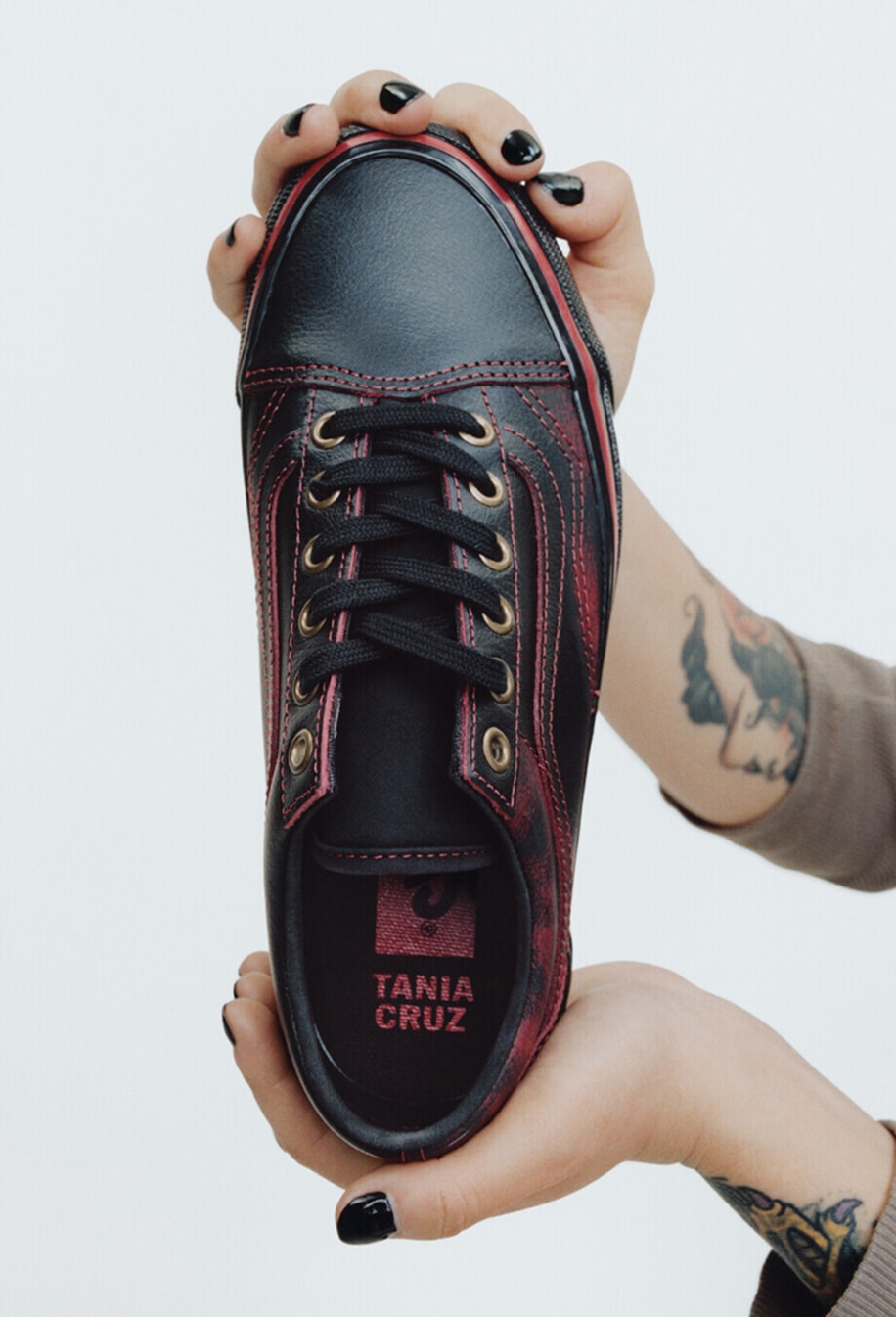 Vans Skater Efron Danzig holds up her Premium Old Skool in a photography studio with her name on the interior sole.