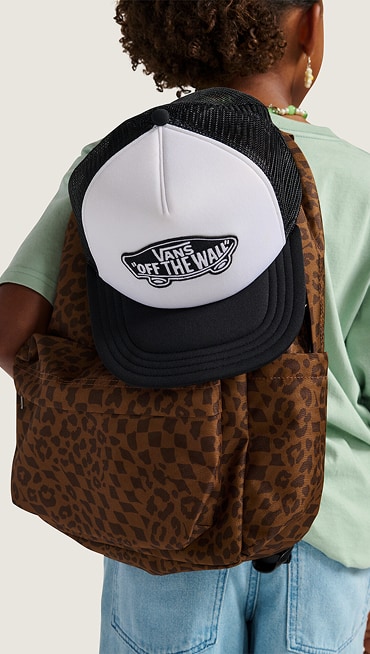 Close-up of a Vans trucker hat on a Dachshund Brown Old Skool Classic Backpack on a girl in a photography studio.