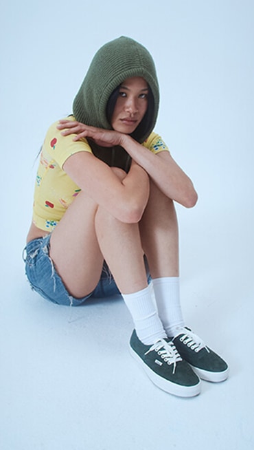 Model Justine sits in a photography studio wearing green pig suede Premium Authentic on the set of Open Set Los Angeles.
