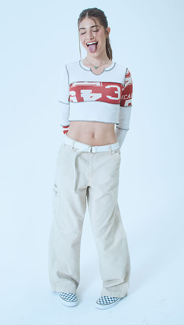 Director Gracie poses with her tongue out wearing a crop top and stargazer blue Premium Classic Slip-On Checkerboard Shoe on Open Set Los Angeles.
