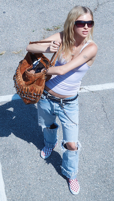 An overhead shot of model Beanie in a parking lot wearing ripped jeans and red Checkerboard Classic Slip-On on the set of Open Set Los Angeles.