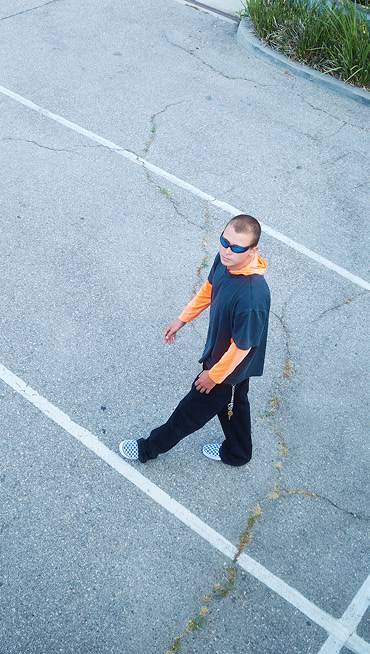 An overhead shot of stylist Landon walking in a parking lot wearing blue Checkerboard Classic Slip-On on the set of Open Set Los Angeles.