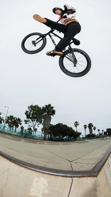 Vans BMX Team Rider Perris Benegas hits a jump in a skate park wearing the Vans x Odyssey BMX Proof WaffleCup.