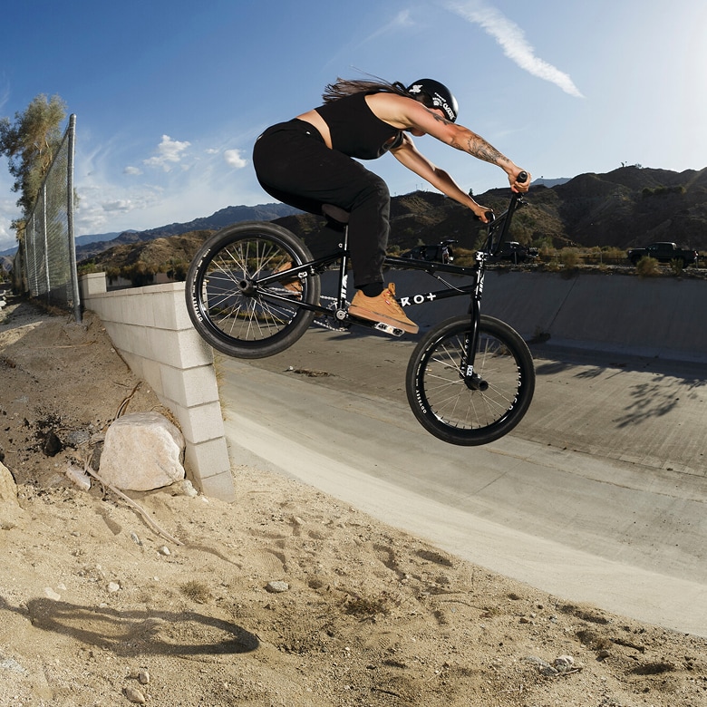 Vans BMX Team Rider Perris Benegas hits a jump in a skate park wearing the Vans x Odyssey BMX Proof WaffleCup.