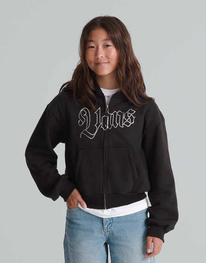 A young girl poses in a black Kids Shining Zip Hoodie in a photography studio.