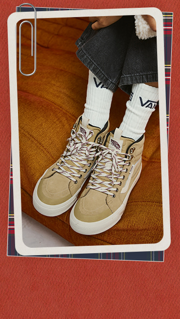 A photograph surrounded by a red and white holiday border of tan Sk8-Hi Insulated shoes on an orange sofa.