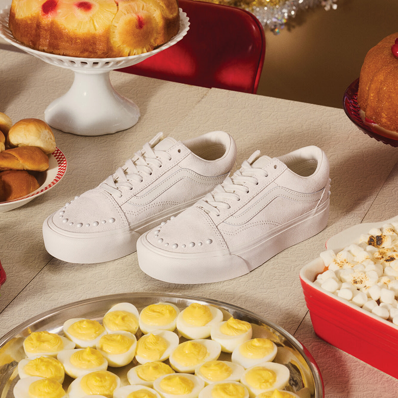 Vans Skate Team Rider sits on an old sofa on the set of a sitcom surrounded by gifts next to a guy with a mohawk.