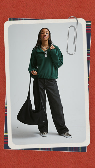 A red holiday border around an image of a young woman wearing an Emerald Polar Sweatshirt in a photography studio.