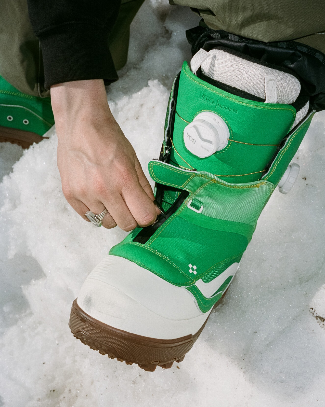 Close up image of someone putting on a pair of Vans snowboard boots.