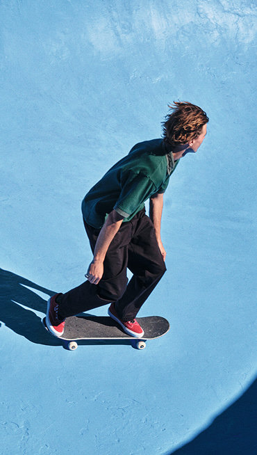 Vans athlete Curren Caples skates down into a bowl wearing red Curren skate shoes.
